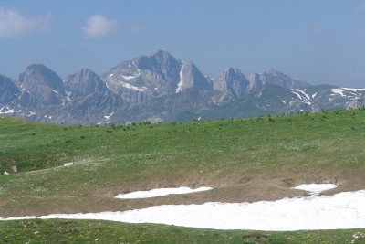 36 - Chiazze di neve prati verdi e Marguareis dal Colletto Seirasso.JPG